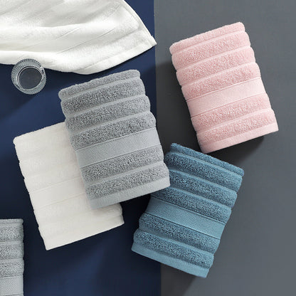 Set of folded towels in white, gray, pink, and blue on a dark surface.