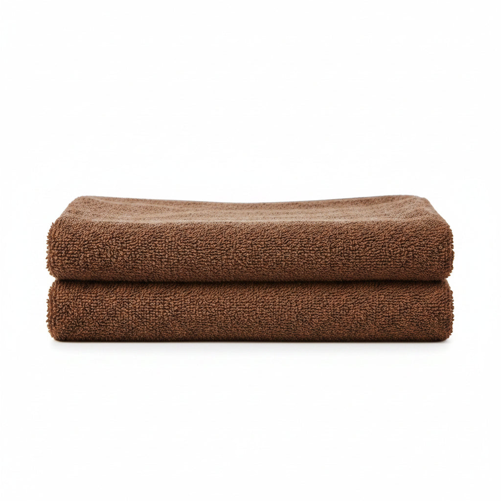 Brown towel hanging on a rack against a gray wall with decorative items below.