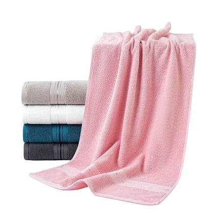Stack of folded towels including pink, gray, white, and blue on a white background