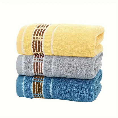 Three folded towels in yellow, gray, and blue with brown striped patterns on a white background.