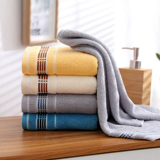 Stack of colorful towels on a wooden surface with a neutral background