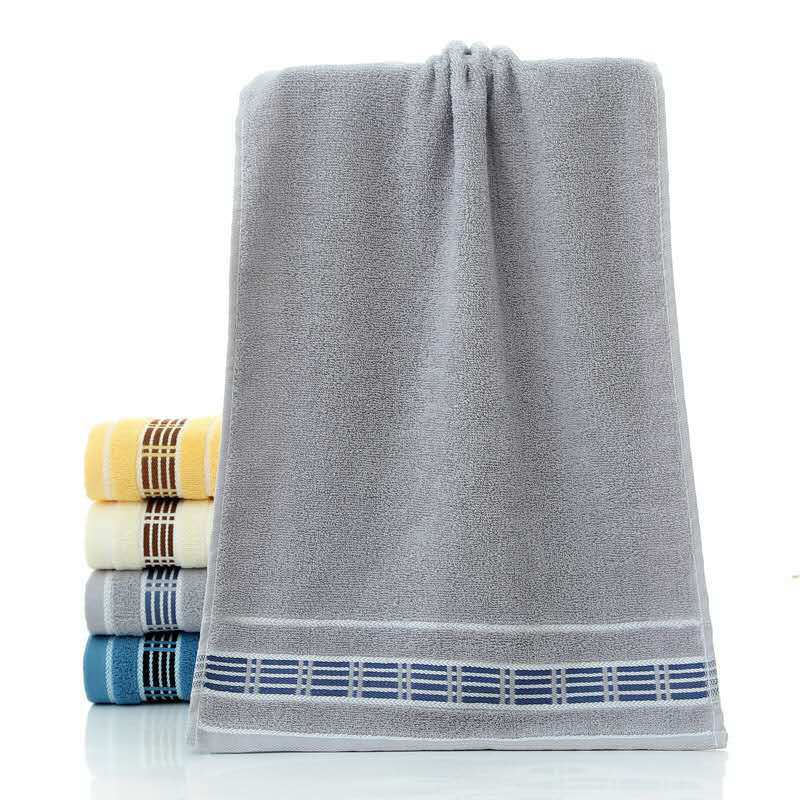 Gray towel with blue border and stack of multicolored towels on a white background