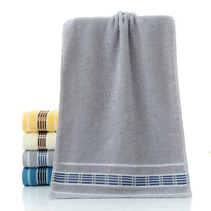 Gray towel with blue border and stack of multicolored towels on a white background