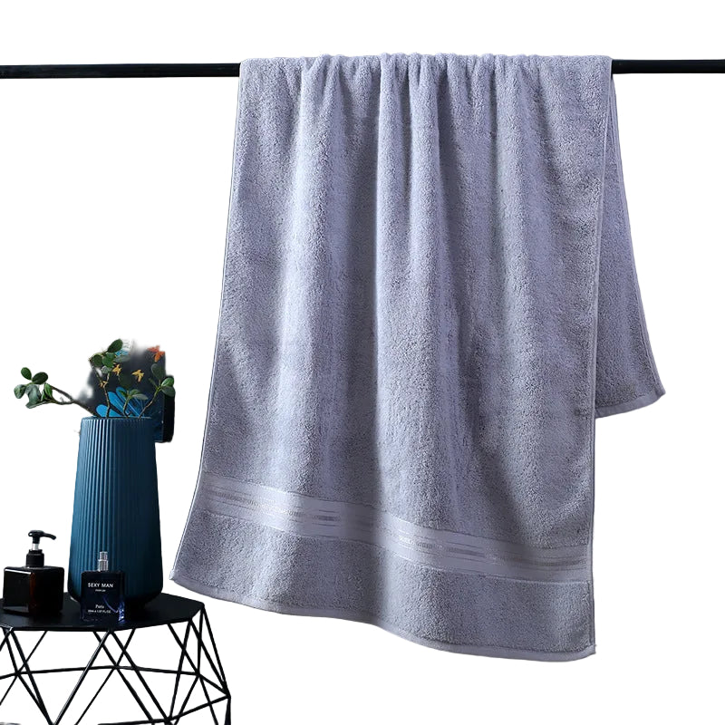 Gray towel hanging on a rack against a dark gray wall with decorative items below.