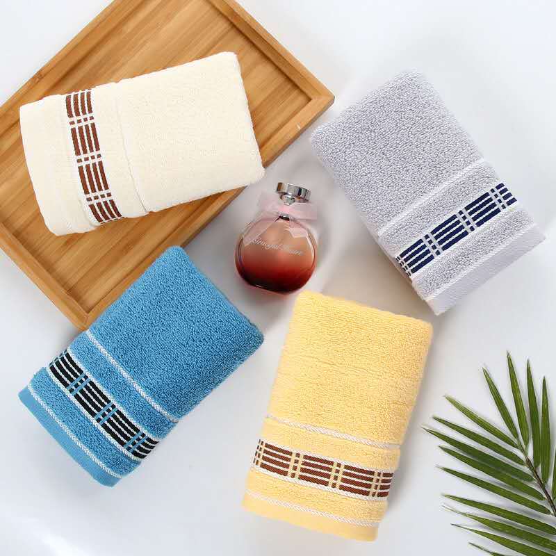 Set of colorful towels with decorative stripes on a wooden tray.